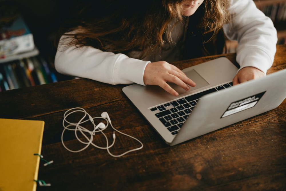 Woman working on a laptop on a wood desk